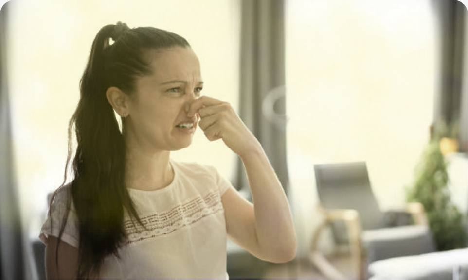 Woman reacting to an unpleasant odor in her home